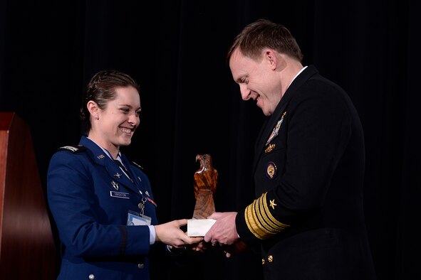 Cadet 1st Class Mary Simonton presents Adm. Mike Rogers, the commander of U.S. Cyber Command, with a token of appreciation for visiting the U.S. Air Force Academy March 15, 2017 and speaking at the Academy Assembly. Along with his Cyber Command duties, Rogers is the director of the National Security Agency and the chief of the Central Security Service. (U.S. Air Force photo/Mike Kaplan
