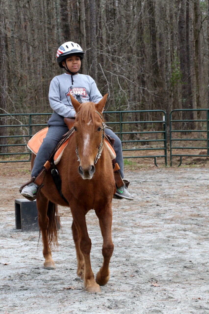 Tyler Patterson, a Boy Scout with Troop 69 out of Columbus, Ga., learns to ride a horse during a visit to the Warrior Outreach Ranch, a nonprofit organization for veterans and family members to relax and unwind through equine therapy. Army Reserve photo by Maj. Michelle Lunato