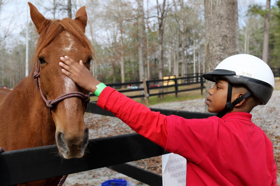 Austin Jones, a Boy Scout with Troop 69 out of Columbus, Gal., pets "Scout" during a visit to The Warrior Outreach Ranch March 11, 2017. Warrior Outreach Ranch is a nonprofit organization for veterans and family members to relax and unwind through equine therapy. (U.S. Army Reserve Photo by Maj. Michelle Lunato/released)