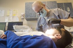 Maj. Royden Jones, 628th Aerospace Medicine Squadron general dentist, performs a dental exam for Jordan Rico, 8 year old son of Tech. Sgt. Jerold Rico, 437th Maintenance Squadron NCO in charge of repair and reclamation, during the annual Give Kids A Smile campaign at Joint Base Charleston, South Carolina, March 17. The event offered free dental including dental exams, prophylaxis, sealants if needed, fluoride treatment and education to children ages two to 12 years old. (U.S. Air Force photo by Staff Sgt. Christopher Hubenthal)