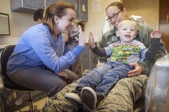 Senior Airman Jasmina Gantt, left, 628th Aerospace Medicine Squadron oral preventative assistant, completes a dental examination for Decklan Gibbs, foreground right, 2 year old son of Airman 1st Class Holly Gibbs, background right, 437th Aerial Port Squadron, during the annual Give Kids A Smile campaign at Joint Base Charleston, South Carolina, March 17. The event offered free dental including dental exams, prophylaxis, sealants if needed, fluoride treatment and education to children ages two to 12 years old. (U.S. Air Force photo by Staff Sgt. Christopher Hubenthal)