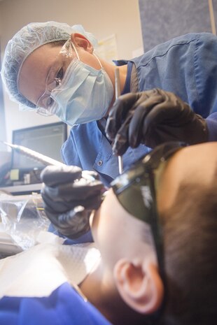 Tech Sgt. Andrea Vera, 628th Aerospace Medicine Squadron dental assistant, performs a dental exam for Jordan Rico, 8 year old son of Tech. Sgt. Jerold Rico, 437th Maintenance Squadron NCO in charge of repair and reclamation, during the annual Give Kids A Smile campaign at Joint Base Charleston, South Carolina, March 17. The event offered free dental including dental exams, prophylaxis, sealants if needed, fluoride treatment and education to children ages two to 12 years old. (U.S. Air Force photo by Staff Sgt. Christopher Hubenthal)