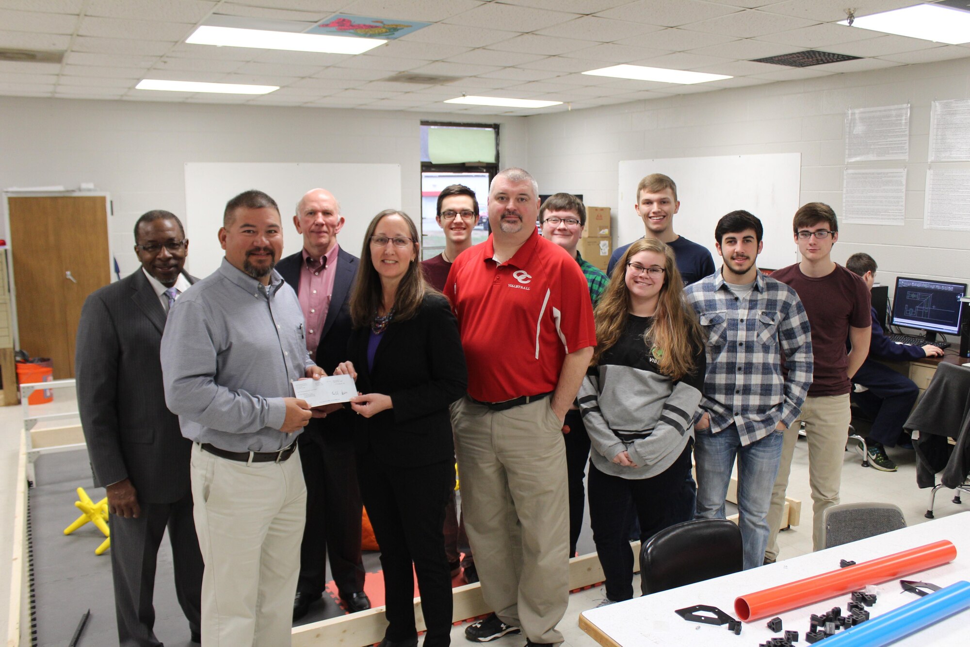 Richard Skipper (second from left), director of Career and Technical Education for Coffee County Schools, accepts a donation from an Arnold Engineering Development Complex contractor, National Aerospace Solutions, LLC, General Manager Cynthia Rivera for Science, Technology, Engineering and Mathematics programs at the Coffee County Central High School, Manchester. AEDC supports many STEM efforts throughout middle Tennessee impacting nearly 19,000 students in more than 60 schools since 2013. Pictured left to right is NAS Technical Director Woodrow Whitlow, Skipper, NAS Deputy General Manager Doug Pearson, Rivera, student Daniel Frideczky, Drafting and STEM instructor Jon Spears, students George Gannon, Heather Bishop, Matthew Wright, John Ballard and Christopher Dillinger. (U.S. Air Force photo/Bob Pullen)