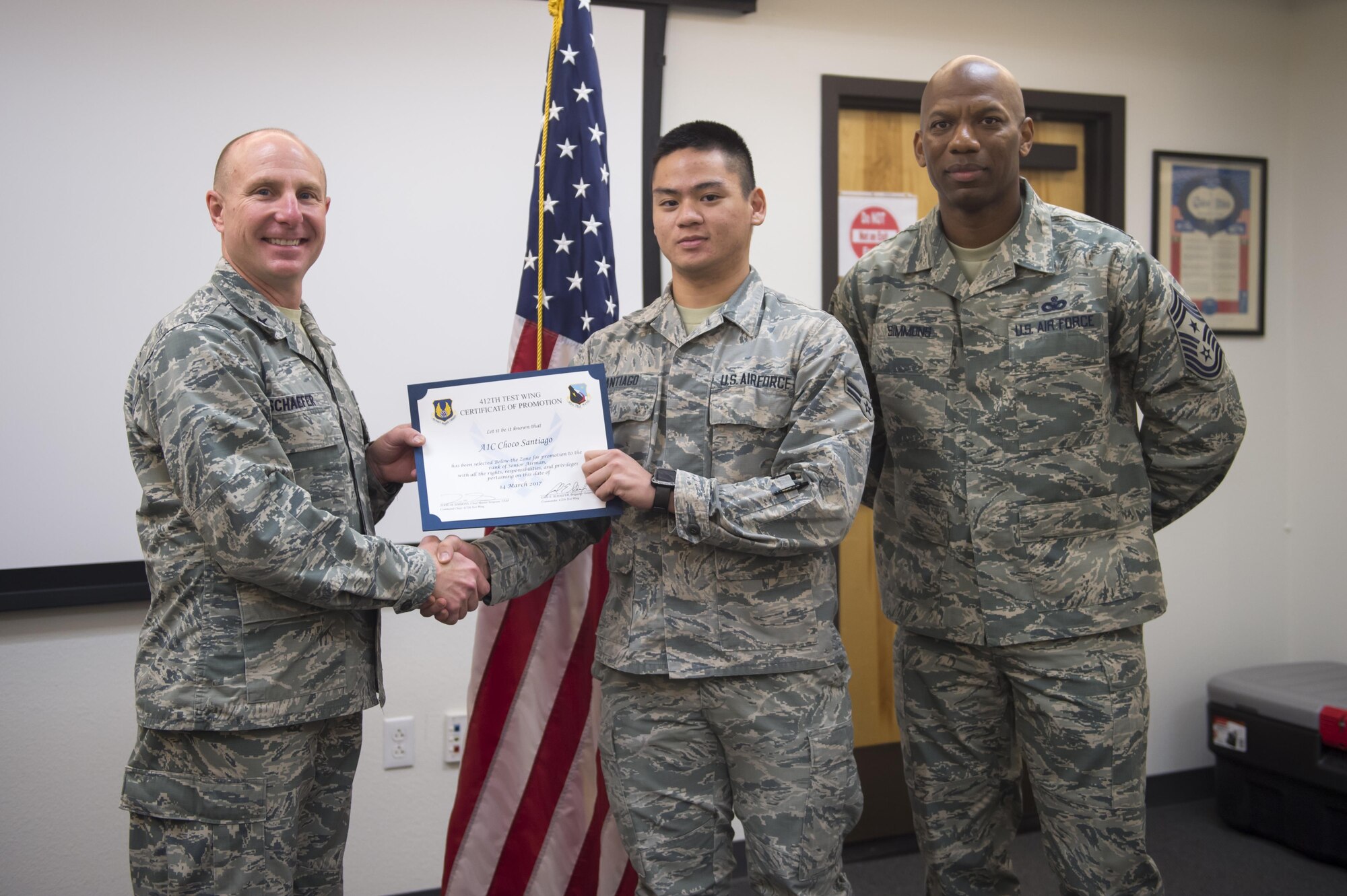 From left: Brig. Gen. Carl Schaefer, 412th Test Wing commander, presented Airman 1st Class Choco Santiago, 412th Comptroller Squadron, with a below-the-zone promotion March 16 along with Chief Master Sgt. Todd Simmons, 412th TW command chief. (U.S. Air Force photo by Kyle Larson)