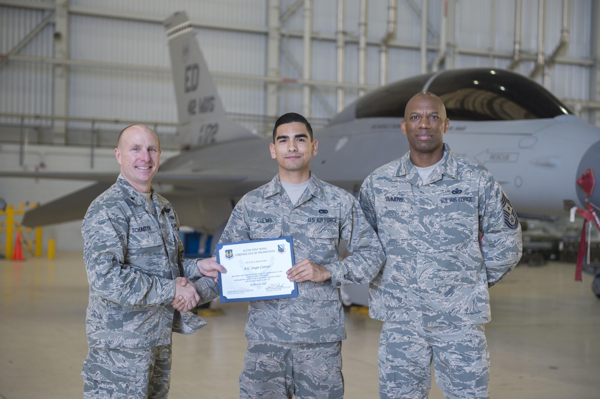 From left: Brig. Gen. Carl Schaefer, 412th Test Wing commander, presented Airman 1st Class Sergio Cuevas, 412th Maintenance Squadron, with a below-the-zone promotion March 16 along with Chief Master Sgt. Todd Simmons, 412th TW command chief. (U.S. Air Force photo by Kyle Larson)