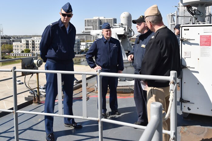 U.S. Navy amphibious dock landing ship USS Whidbey Island (LSD 41) visited Charleston, South Carolina, over St. Patrick’s day weekend. Navy Lt. David Pagan, center right, describes the ship’s weapons systems while giving a tour to Air Force Col. Rick Mathews, commander, 628th Mission Support Group, center left; Air Force Lt. Col. Matthew Brennan, commander, 628th Civil Engineer Squadron, left and Navy Cmdr. William Edenbeck Naval Support Activity Charleston’s Executive Officer, right.  The Whidbey Island moored at Union Pier Terminal in downtown Charleston.