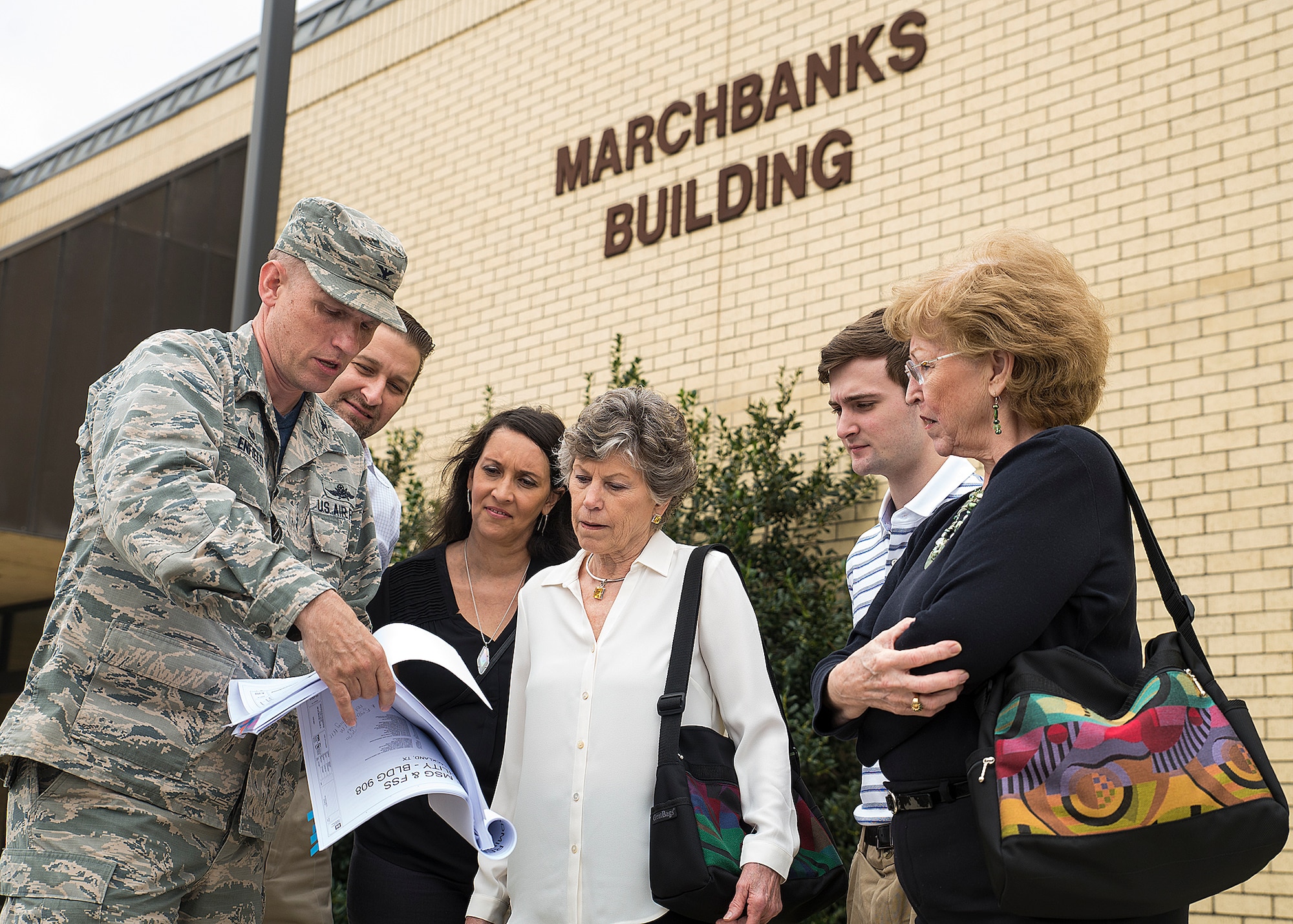 Col. David Enfield, 433rd Mission Support Group commander, shows Peggy Marchbanks, the new-construction blueprints of the Marchbanks Building March 17, 2017 at Joint Base San Antonio-Lackland, Texas. Peggy Marchbanks  was accompanied by her son Tobin Marchbanks, daughter-inlaw Lorisha Marchbanks, grandson Colin Marchbanks, and sister Nancy Richter. She is the widow of Maj.Gen. Tom E. Marchbanks, Jr. , the first chief, Air Force Reserve, and former 433rd Airlift Wing commander. (U.S.  Air Force photo by Benjamin Faske)