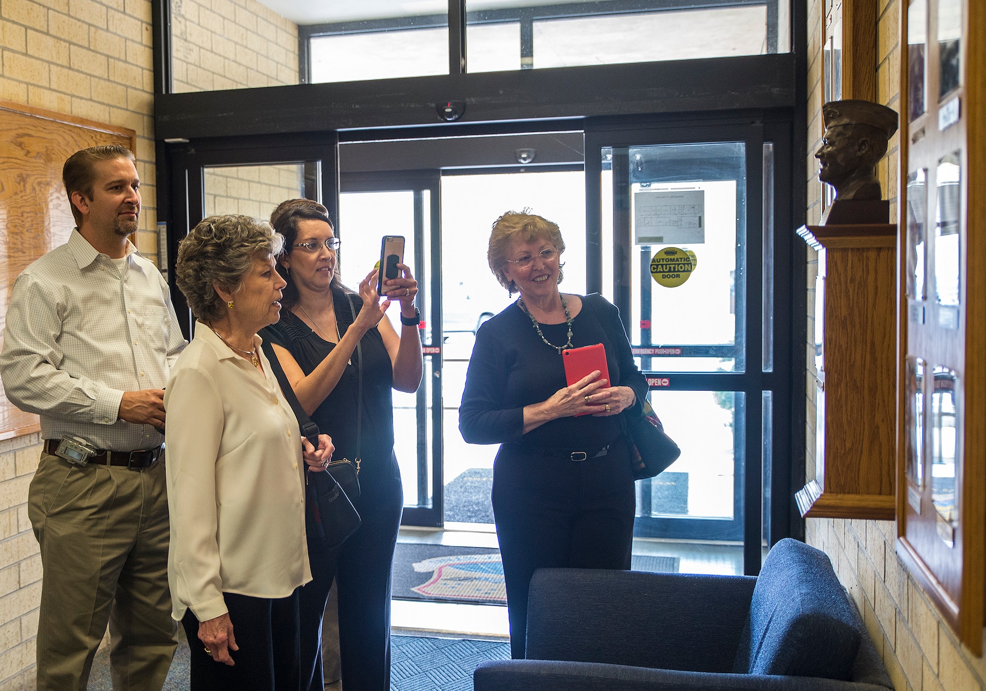 Peggy Marchbanks views the bronze bust of her late husband Maj.Gen Tom E. Marchbanks, Jr. at the entrance to the Marchbanks Building March 17, 2017 at Joint Base San Antonio-Lackland, Texas. Peggy Marchbanks  was accompanied by her son Tobin Marchbanks, daughter-inlaw Lorisha Marchbanks, grandson Colin Marchbanks, and sister Nancy Richter. (U.S.  Air Force photo by Benjamin Faske)