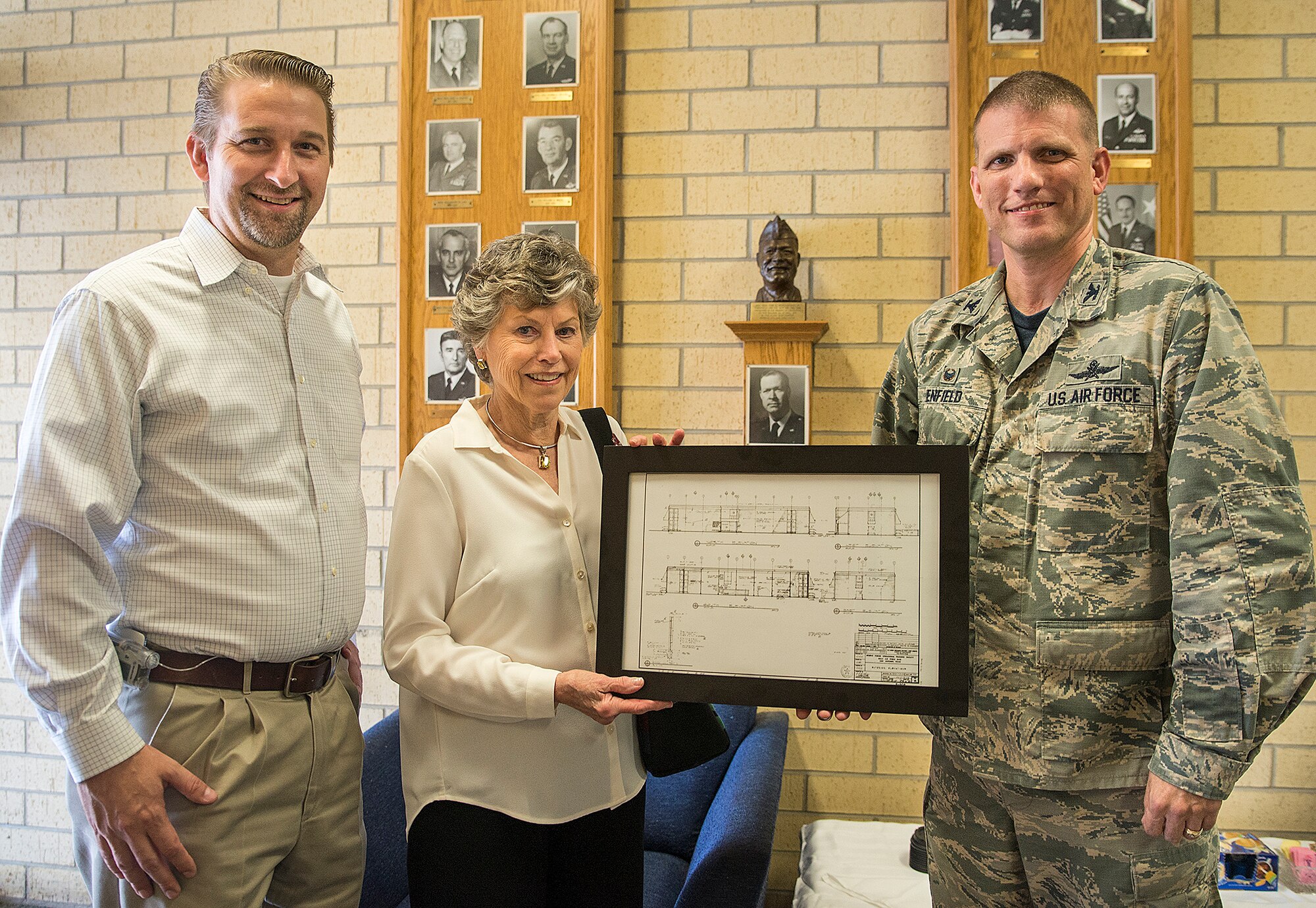 Col. David Enfield, 433rd Mission Support Group commander, presents Peggy Marchbanks and her son Tobin Marchbanks, with a framed copy of the original blueprints of the Marchbanks building March 17, 2017 at Joint Base San Antonio-Lackland, Texas. Peggy Marchbanks  was accompanied by her son Tobin Marchbanks, daughter-inlaw Lorisha Marchbanks, grandson Colin Marchbanks, and sister Nancy Richter. She is the widow of Maj.Gen. Tom E. Marchbanks, Jr. the first chief, Air Force Reserve, and former 433rd Airlift Wing commander. (U.S.  Air Force photo by Benjamin Faske)