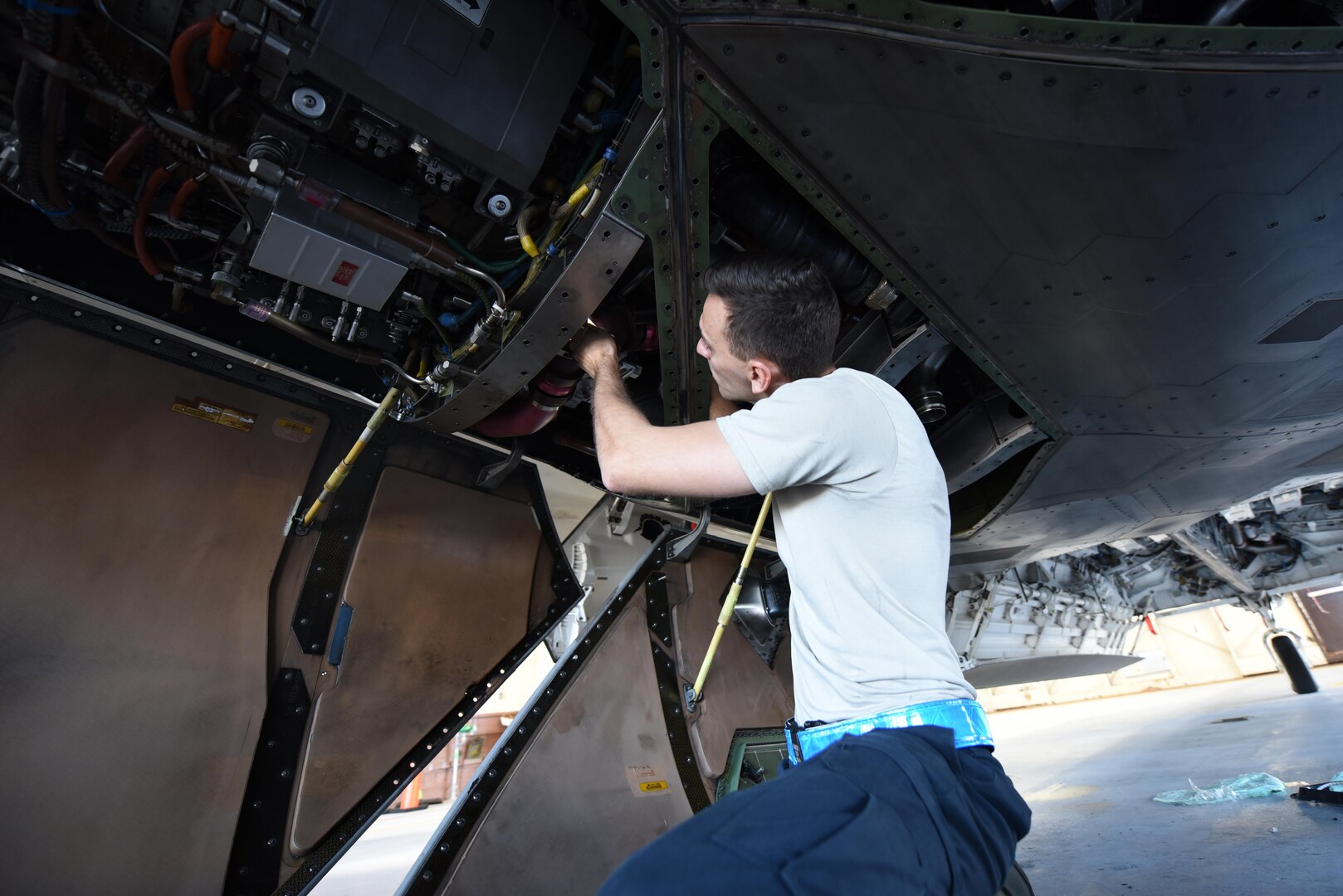 U.S. Air Force Tech. Sgt. Robert Mackle, 325th Aircraft Maintenance Squadron dedicated crew chief, inspects the underbelly of an F-22 Raptor in Hangar 2 at Tyndall Air Force Base, Fla., March 20, 2017. Prior to a sortie, dedicated crew chiefs like Mackle inspect and maintain the aircraft to ensure the F-22’s operational readiness. (U.S. Air Force photo by Senior Airman Solomon Cook/Released)