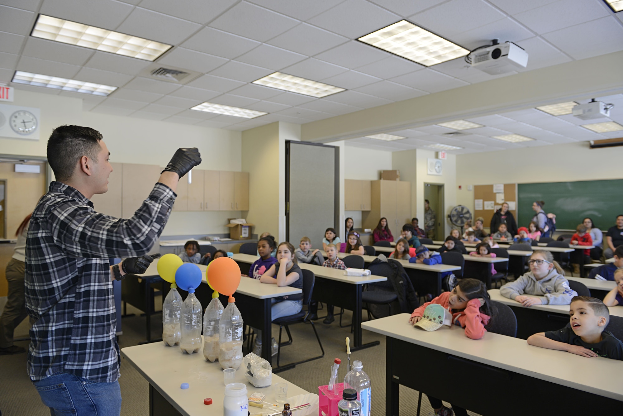 Army 2nd Lt. Roger Tran, 103rd Civil Support Team nuclear medical science officer, presents different chemical reactions to children during the Spring Break Science Program at the Joint Base Elmendorf-Richardson Library, March 17, 2017. The program offered various interactive experiments and activities revolving around science for children during the week of spring break. 