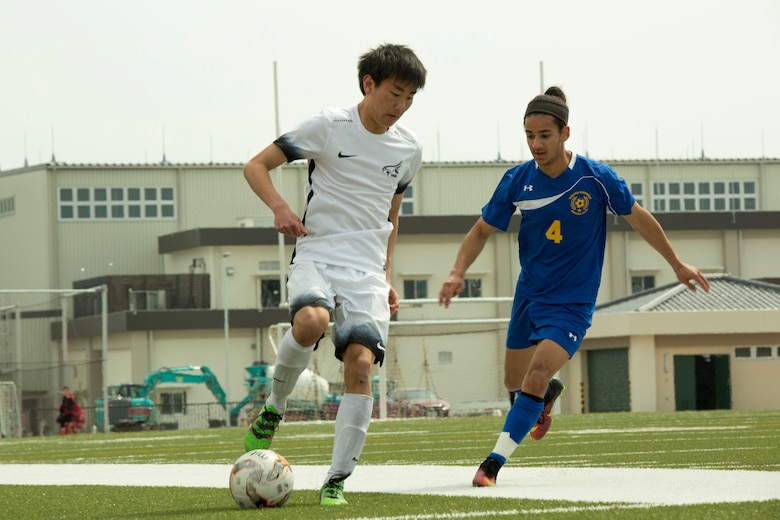 A Yokota High School soccer player from Yokota Air Base attempts to steal the ball from a Canadian Academy soccer player from Kobe during the Perry Cup Soccer Tournament 2017 at Marine Corps Air Station Iwakuni, Japan, March 18, 2017. Yokota won the game against Canadian Academy 5-0 and second place in the Maroon Group. (U.S. Marine corps photo by Pfc. Stephen Campbell)