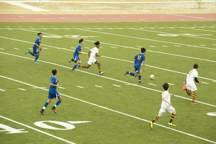 A player from the Yokota High School soccer team out of Yokota Air Force Base kicks a soccer ball down the field to score a goal against Matthew C. Perry High School soccer team during the Perry Cup Soccer Tournament 2017 at Marine Corps Air Station Iwakuni, Japan, March 18, 2017. Yokota beat M.C. Perry 1-0 and won second place in the Maroon Group. (U.S. Marine Corps photo by Pfc. Stephen Campbell)