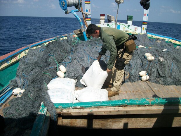 A Sailor assigned to USS Laboon (DDG 58) offloads bags containing Hashish from a dhow in the Arabian Sea, March 17. Laboon Sailors intercepted the dhow and seized 500 kg of Hashish, their second successful drug interdiction operation in five days. Laboon, operating as part of Combined Task Force (CTF) 150, is attached to Destroyer Squadron (DESRON) 22.