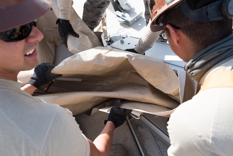 Airmen assigned to the 407th Expeditionary Civil Engineer Squadron and 577th Expeditionary Prime Beef Squadron install canvas on a new 4k dome at the 407th Air Expeditionary Group, March 21, 2017. The new structure will provide 4,000 square feet of covered area to maintain vehicles operating in support of Operation Inherent Resolve. (U.S. Air Force photo/Master Sgt. Benjamin Wilson)(Released)