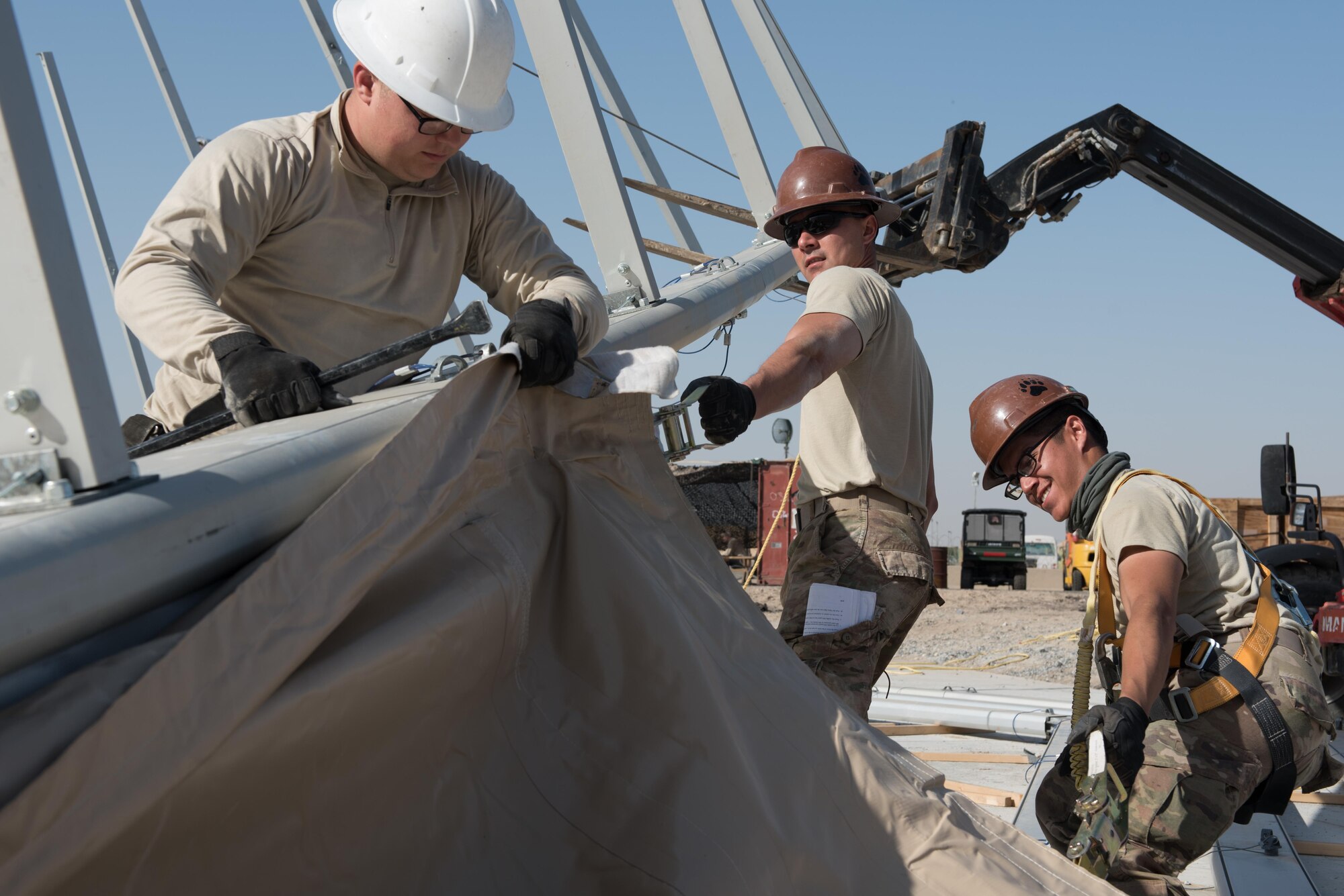 Airmen assigned to the 407th Expeditionary Civil Engineer Squadron and 577th Expeditionary Prime Beef Squadron install canvas on a new 4k dome at the 407th Air Expeditionary Group, March 21, 2017. The new structure will provide 4,000 square feet of covered area to maintain vehicles operating in support of Operation Inherent Resolve. (U.S. Air Force photo/Master Sgt. Benjamin Wilson)(Released)