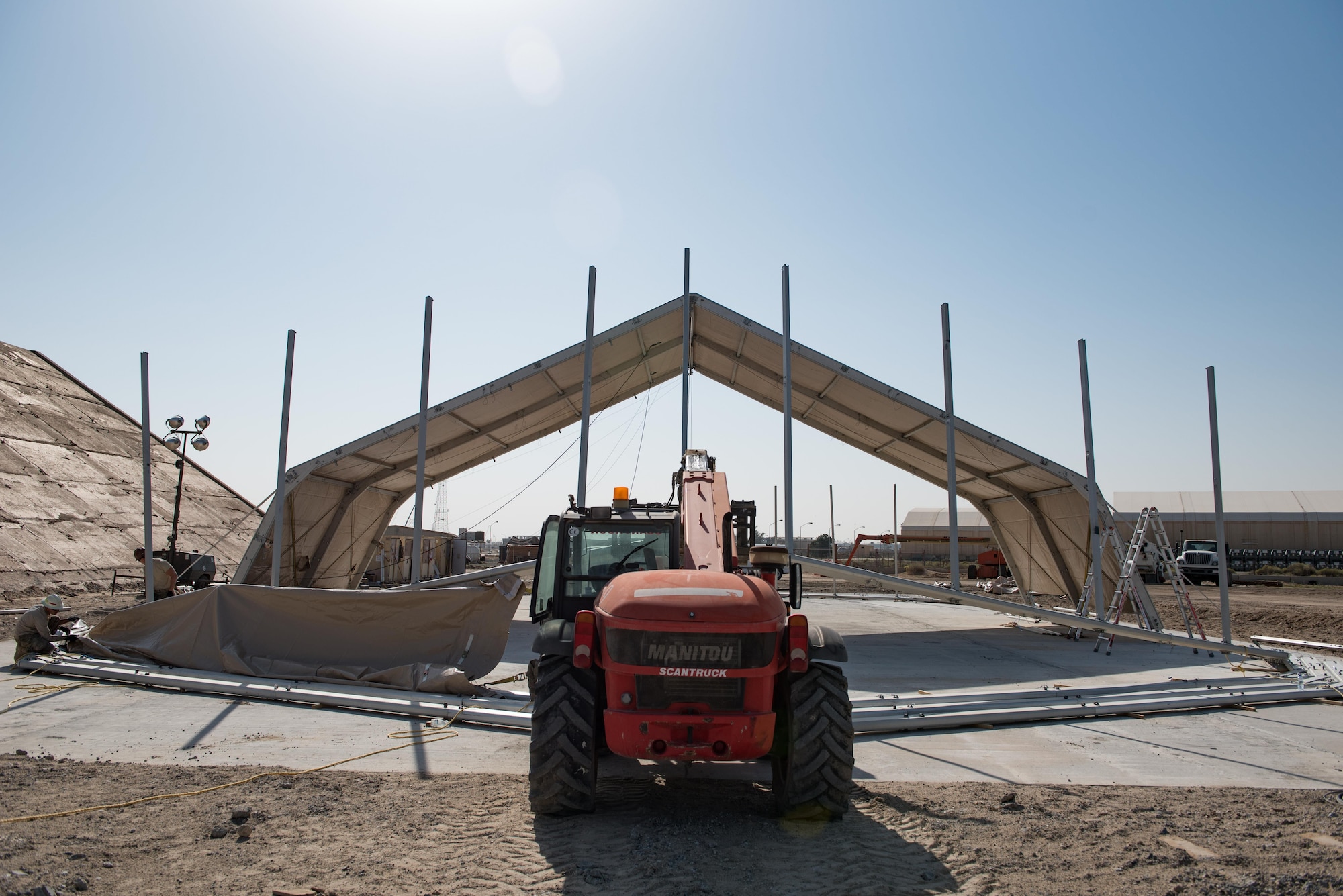 Airmen assigned to the 407th Expeditionary Civil Engineer Squadron and 577th Expeditionary Prime Beef Squadron install canvas on a new 4k dome at the 407th Air Expeditionary Group, March 21, 2017. The new structure will provide 4,000 square feet of covered area to maintain vehicles operating in support of Operation Inherent Resolve.  (U.S. Air Force photo/Master Sgt. Benjamin Wilson)(Released)