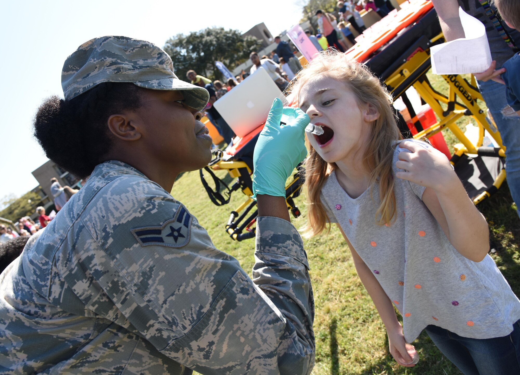 Airman 1st Class Chante Birdlong, 81st Medical Operations Squadron administration technician, administers juice to Madison Maxey, daughter of Kristen Maxey, during Operation Hero March 18, 2017, on Keesler Air Force Base, Miss. The activities at the event were designed to help children better understand what their parents do when they deploy. (U.S. Air Force photo by Kemberly Groue)