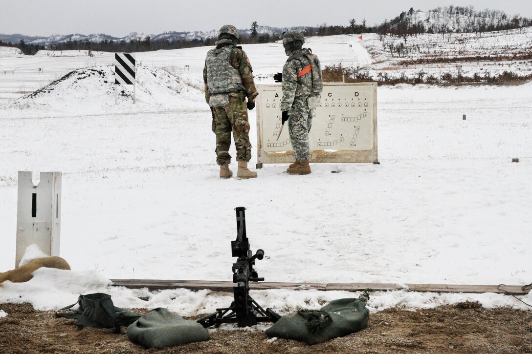 An Army reservist and a range safety officer check the target during zero and qualification with an M240B machine gun during Operation Cold Steel at Fort McCoy, Wis., March 13, 2017. Army Reserve photo by Staff Sgt. Debralee Best