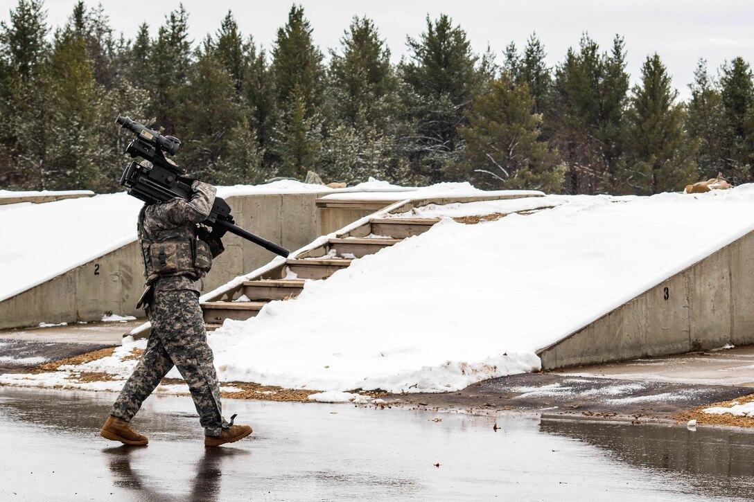 An Army reservist carries an MK-19 grenade launcher for qualification setup during Operation Cold Steel at Fort McCoy, Wis., March 13, 2017. Army Reserve photo by Staff Sgt. Debralee Best