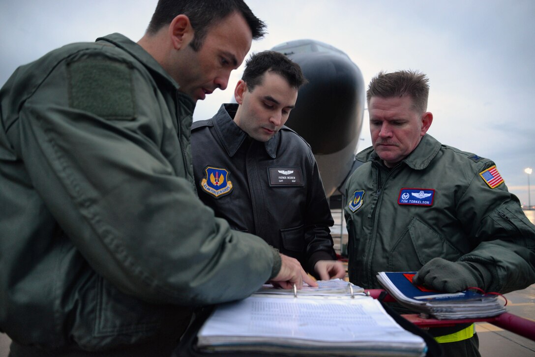 Left to right, U.S. Air Force Maj. Frederick Finke, Capt. Patrick McGrew, 351st Air Refueling Squadron pilots, and Col. Thomas Torkelson, 100th Air Refueling Wing commander look through the preflight checklist March 17, 2017, on Naval Station Rota, Spain. KC-135 Stratotankers are providing air refueling support for French Forces combat operations in Mali and North Africa. (U.S. Air Force photo by Senior Airman Christine Halan)