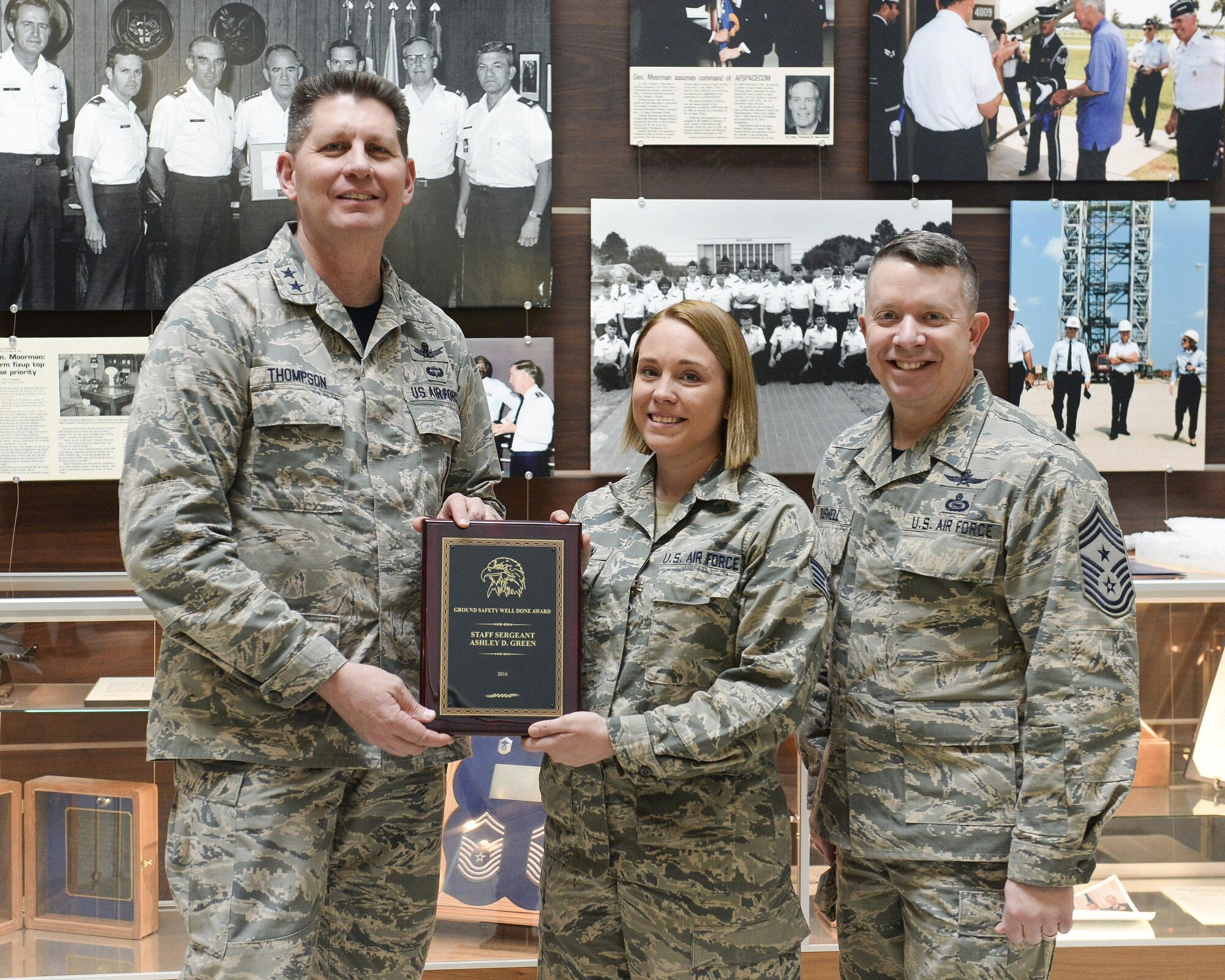 PETERSON AIR FORCE BASE, Colo.—U.S. Air Force Maj. Gen. David Thompson (left) and Chief Master Sgt. Brendan Criswell (right), vice commander and command chief of Air Force Space Command, present Staff Sgt. Ashley Green (center) with the Air Force Chief of Safety Ground Safety Job Well Done Award at Peterson Air Force Base, Colo., March 3, 2017.  Green, who is assigned to the Advanced Space Operations School at Peterson Air Force Base, began teaching child seat safety after a 2014 auto accident where a car seat saved her 3-year-old daughter's life. (U.S. Air Force photo by Dave Grim)