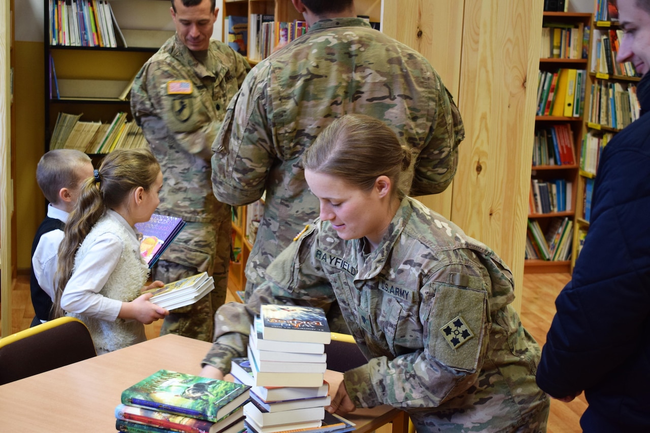 Army Spc. Paige Rayfield, with the 3rd Battalion, 29th Field Artillery Regiment, helps stock new bookcases during a visit to the Mielenku Drawskim Primary School in Drawsko Pomorskie, Poland, March 10, 2017. The battalion’s soldiers helped to construct the bookcases for the school during their off-duty hours, continuing a tradition of school volunteerism begun at the unit’s home station of Fort Carson, Colo. Army photo by Capt. Brett Tinder