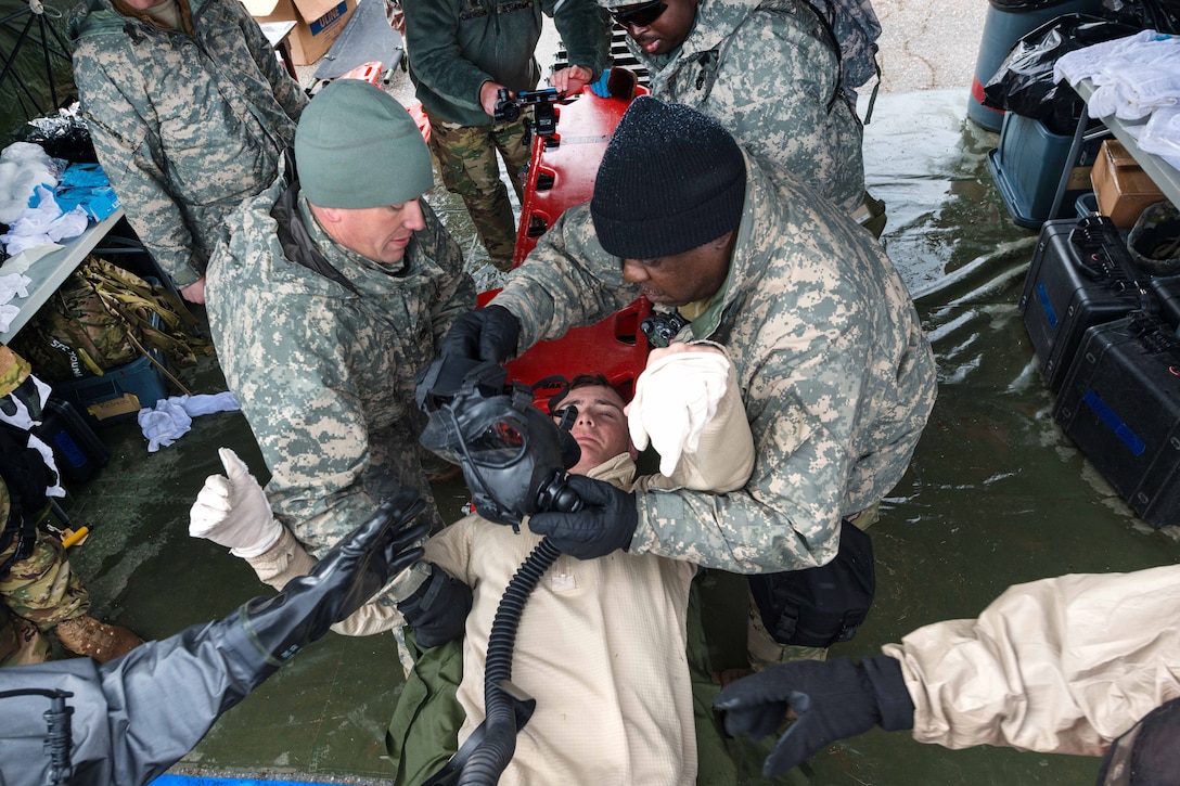 South Carolina Army National Guard Pfc. Samuel Sides, lying down, is decontaminated and triaged after becoming nonresponsive during a U.S. Army North joint training exercise in Owings Mills, Md., March 10, 2017. Sides, a medic, is assigned to the South Carolina Army National Guard’s 251st Area Support Medical Company. Air National Guard photo by Tech. Sgt. Jorge Intriago