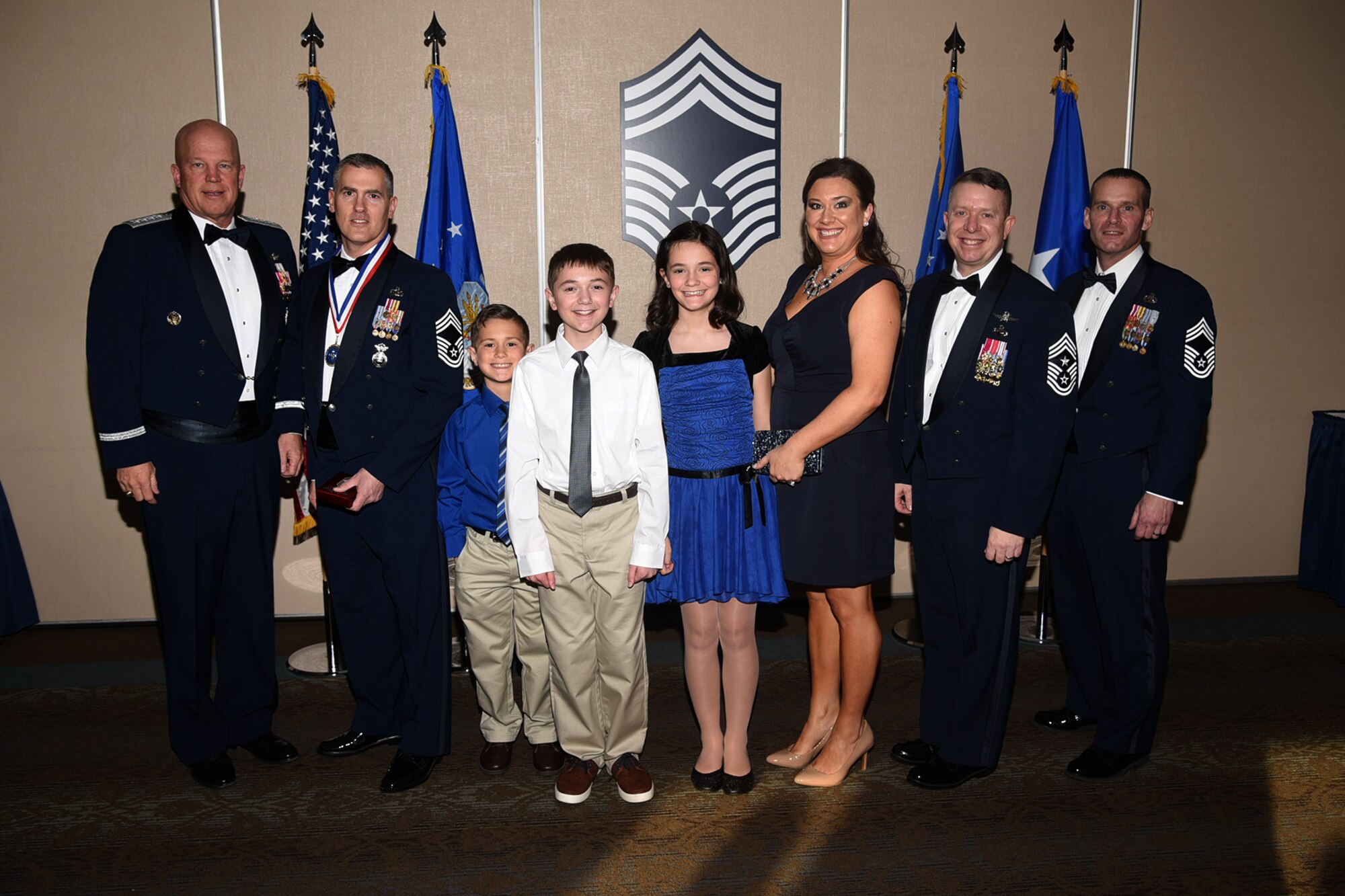PETERSON AIR FORCE BASE, Colo. - Chief Master Sgt. select Henry Adkins, 721st Security Forces Squadron, and family receive the chiefs medallion from General Jay Raymond, Air Force Space Command commander, Chief Master Sgt. Brendan Criswell, Air Force Space Command command master chief, and Chief Master Sgt. Douglas Lawless, Air Force Space Command chief enlisted manager, comptroller directorate. (U.S. Air Force photo by Robb Lingley)
