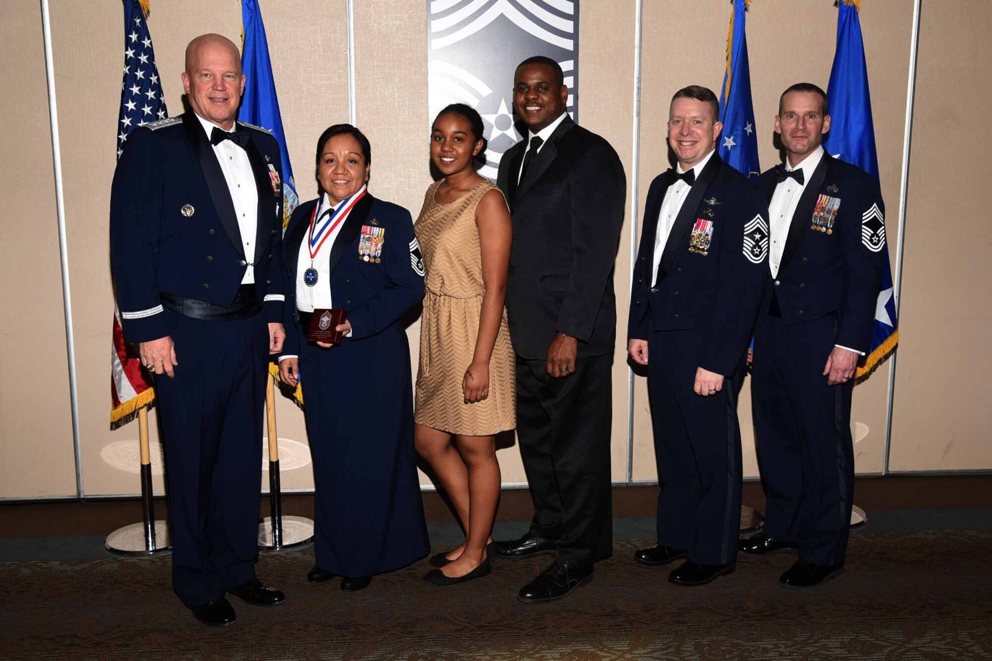 PETERSON AIR FORCE BASE, Colo. – Chief Master Sgt. select Eva Rogers, 21st Comptrollers Squadron, and family receive the chiefs medallion from General Jay Raymond, Air Force Space Command commander, Chief Master Sgt. Brendan Criswell, Air Force Space Command command master chief, and Chief Master Sgt. Douglas Lawless, Air Force Space Command chief enlisted manager, comptroller directorate. (U.S. Air Force photo by Robb Lingley)