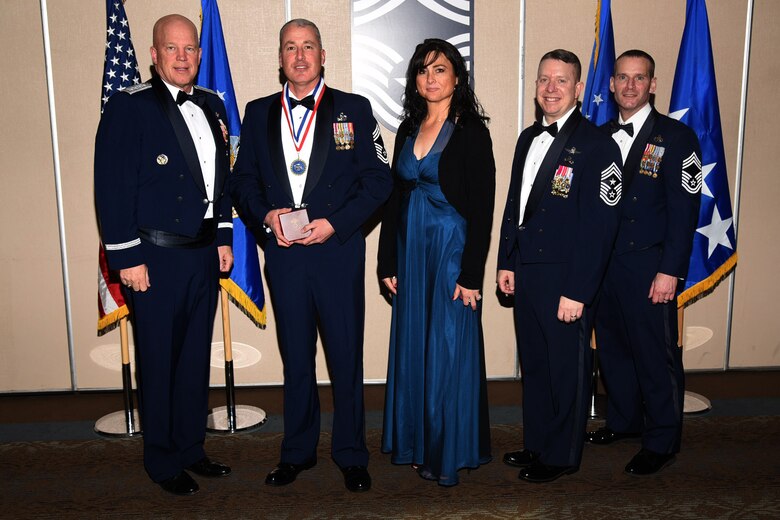 PETERSON AIR FORCE BASE, Colo. - Chief Master Sgt. select Matthew Console, 21st Space Wing Communication Squadron, and his wife receive the chiefs medallion from General Jay Raymond, Air Force Space Command commander, Chief Master Sgt. Brendan Criswell, Air Force Space Command command master chief, and Chief Master Sgt. Douglas Lawless, Air Force Space Command chief enlisted manager, comptroller directorate. (U.S. Air Force photo by Robb Lingley)