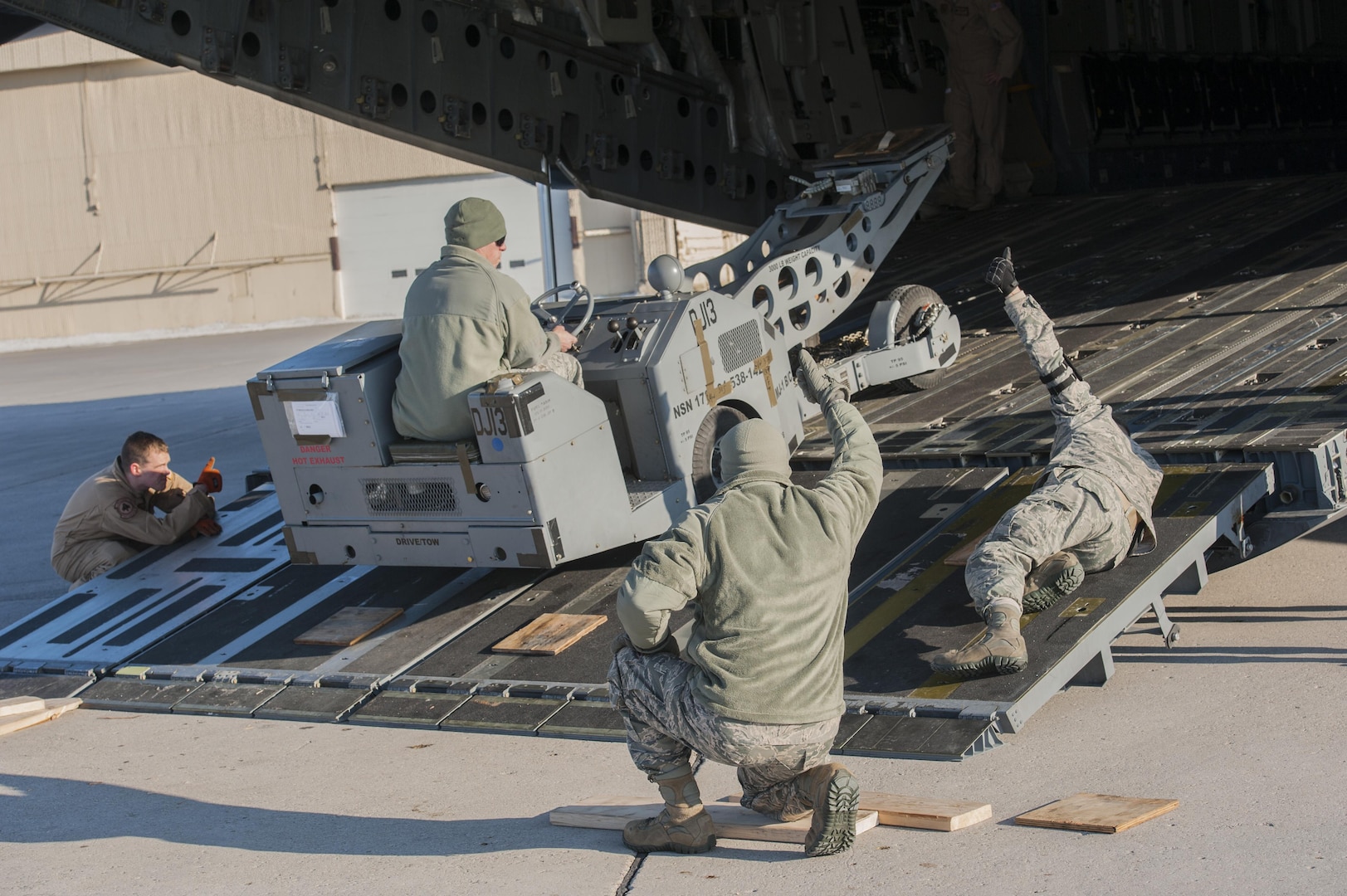 (From left) Staff Sgt. Conor Gillespie, 21st Airlift Squadron loadmaster from Travis Air Force Base, Calif., aids the 5th Logistics Readiness Squadron deployment distributions flight load cargo onto a C-17 Globemaster III at Minot AFB, N.D., March 3, 2017. The mass deployment included more than 400 deployers and 290,000 pounds of cargo. (U.S. Air Force photo/Airman 1st Class Jonathan McElderry)