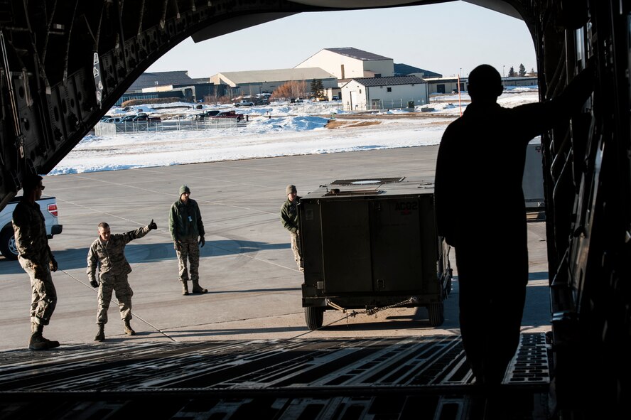 Airmen with the 5th Logistics Readiness Squadron deployment distributions flight load cargo onto a C-17 Globemaster III at Minot Air Force Base, N.D., March 3, 2017. Flight members planned and executed logistics operations, and loaded cargo to support a U.S. Central Command deployment from Minot AFB. (U.S. Air Force photo/Airman 1st Class Jonathan McElderry)