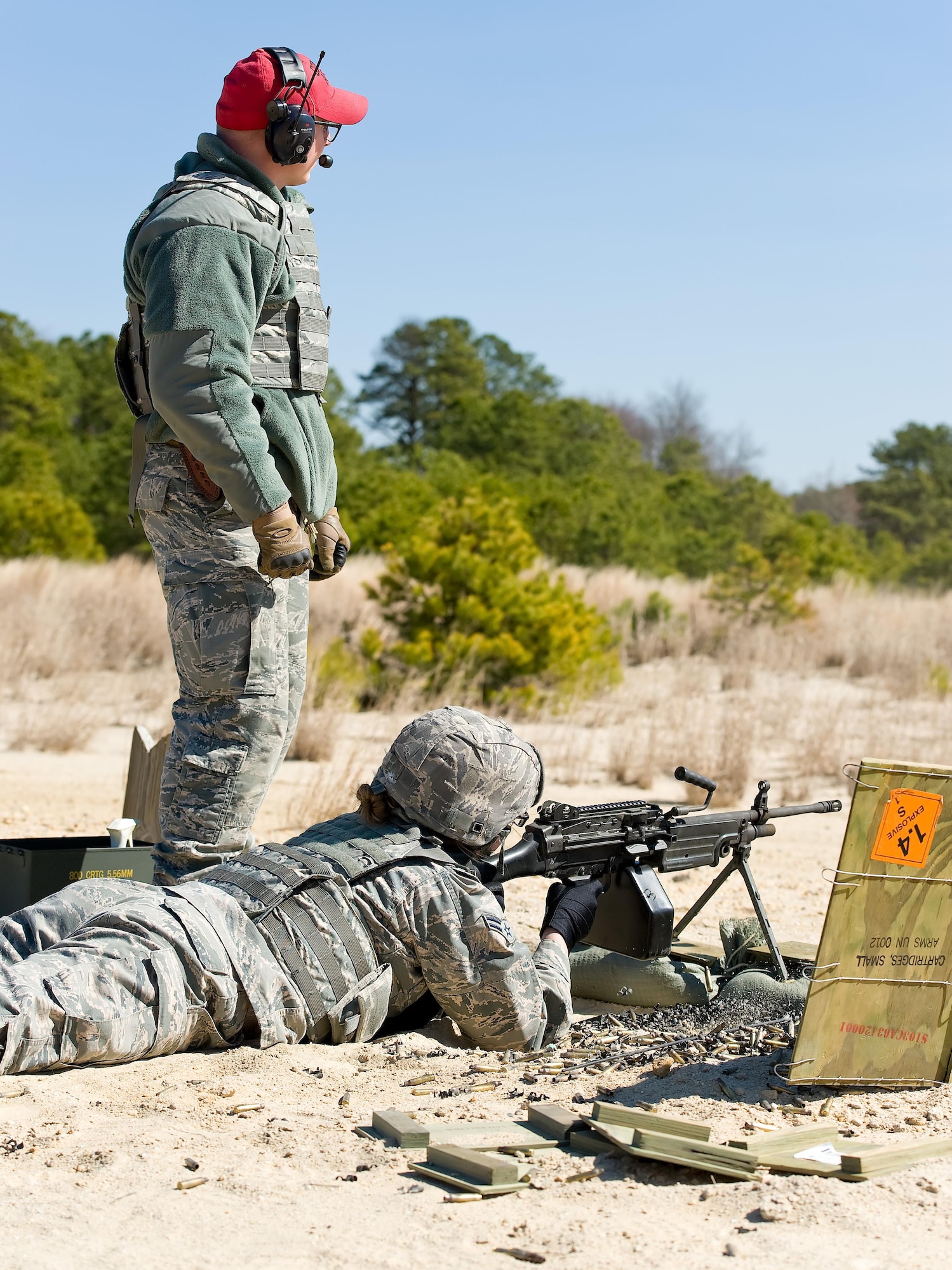 Senior Airman Jeffrey Burton, 436th Security Forces Squadron Combat Arms instructor, verifies the strike pattern of the M-249 Light Machine Gun being fired by Airman 1st Class Annamae Prentiss, 436th SFS response force member, March 9, 2017, at Range 7 on Joint Base McGuire-Dix-Lakehurst, N.J. Prentiss was one of four 436th SFS members assigned to Dover Air Force Base, Del., that trained on the M-249 by firing at decommissioned tanks placed at various distances between 200 to 1,200 meters. (U.S. Air Force photo by Roland Balik)