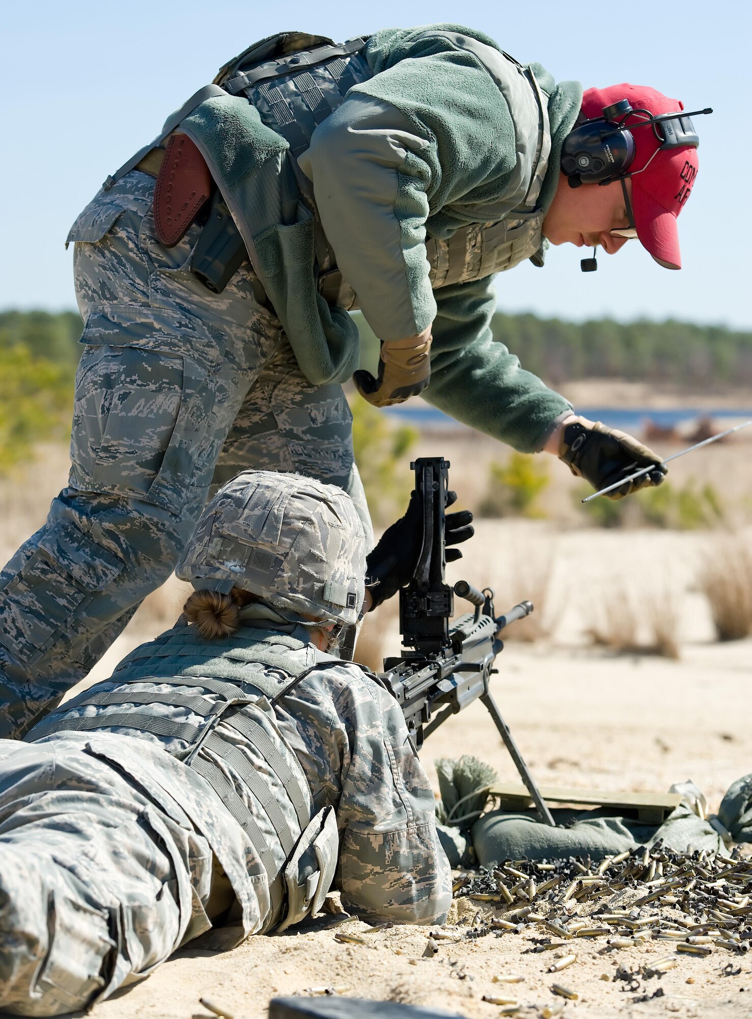 Senior Airman Jeffrey Burton, 436th Security Forces Squadron Combat Arms instructor, prepares to “rod” the barrel of the M-249 Light Machine Gun being fired by Airman 1st Class Annamae Prentiss, 436th SFS response force member, March 9, 2017, at Range 7 on Joint Base McGuire-Dix-Lakehurst, N.J. Burton rodded the barrel to ensure it was free from any obstruction prior to a barrel change on the M-249. (U.S. Air Force photo by Roland Balik)