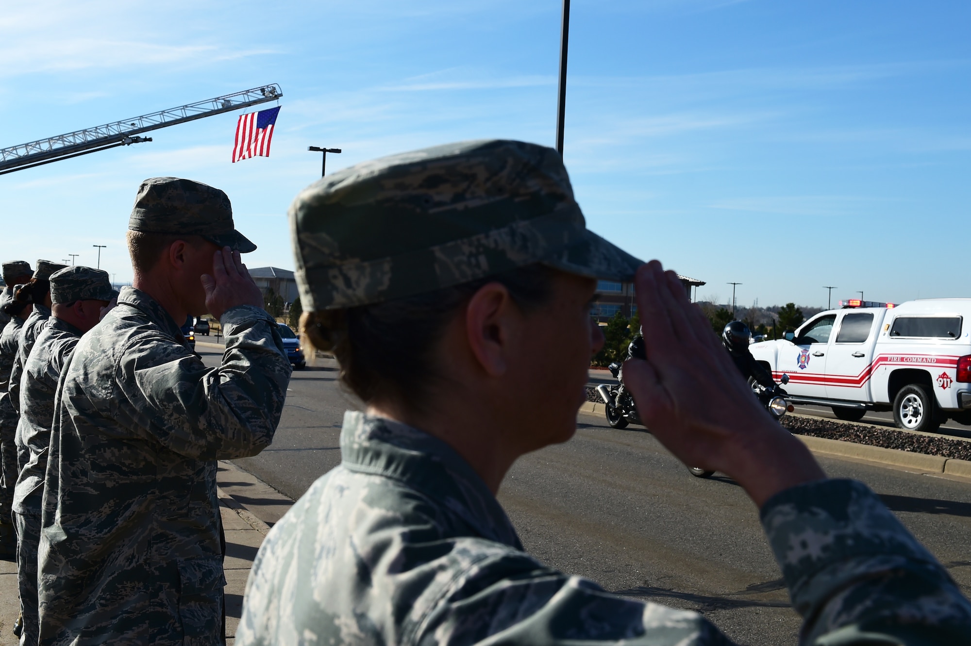 Members of Team Buckley render a final salute to Senior Airmen Tien Tran, 566th Intelligence Squadron, March 21, 2017, on Buckley Air Force Base, Colo. The funeral procession took place along Aspen Street, from the Mississippi Gate to the 6th Ave. Gate. He was transferred from the Denver International Airport to Hilo, Hawaii, for his internment March 24. (U.S. Air Force photo by Airman Jacob Deatherage/Released)