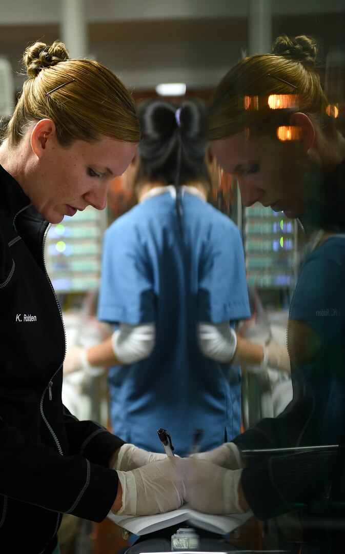 U.S. Army Capt. Kari Rodden, an Army Institute of Surgical Research nurse, annotates patient treatment information in preparation for transport from South America to San Antonio, Texas, Feb. 16, 2017. Nine medics from the 59th Medical Wing and the San Antonio Military Medical Center went on a mission to South America to transport a patient back to the U.S. for treatment for the influenza virus. (U.S. Air Force photo/Staff Sgt. Jerilyn Quintanilla)