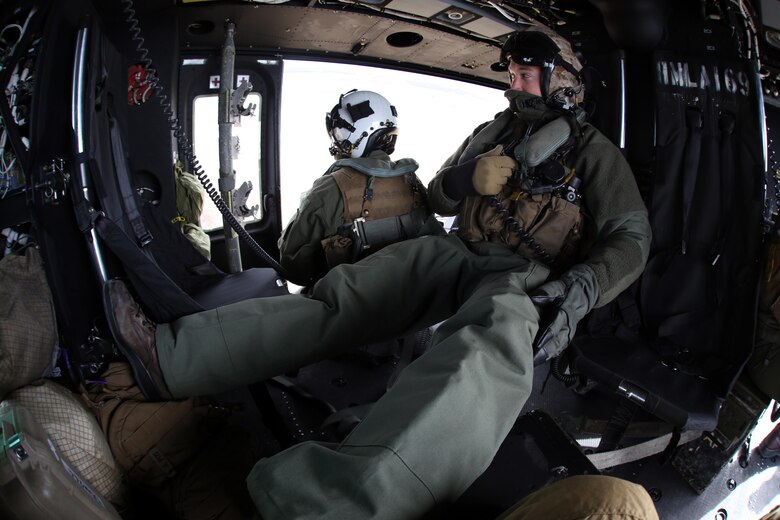 Cpl. Landon Cheek watches the skies from the inside a UH-1Y Venom during cold weather operations over Fort Drum, N.Y., March 10, 2017. The training, which began March 8 and will continue until March 20, involves learning how to deal with the challenges that come with working in cold, and sometimes snowy and icy environments. With snowy obstacles and temperatures in the sub-zero range, the Marines will learn how to adapt and overcome. Cheek is a crew chief with Marine Light Attack Helicopter Squadron 269, Marine Aircraft Group 29, 2nd Marine Aircraft Wing. (U.S. Marine Corps photo by Cpl. Mackenzie Gibson/Released)