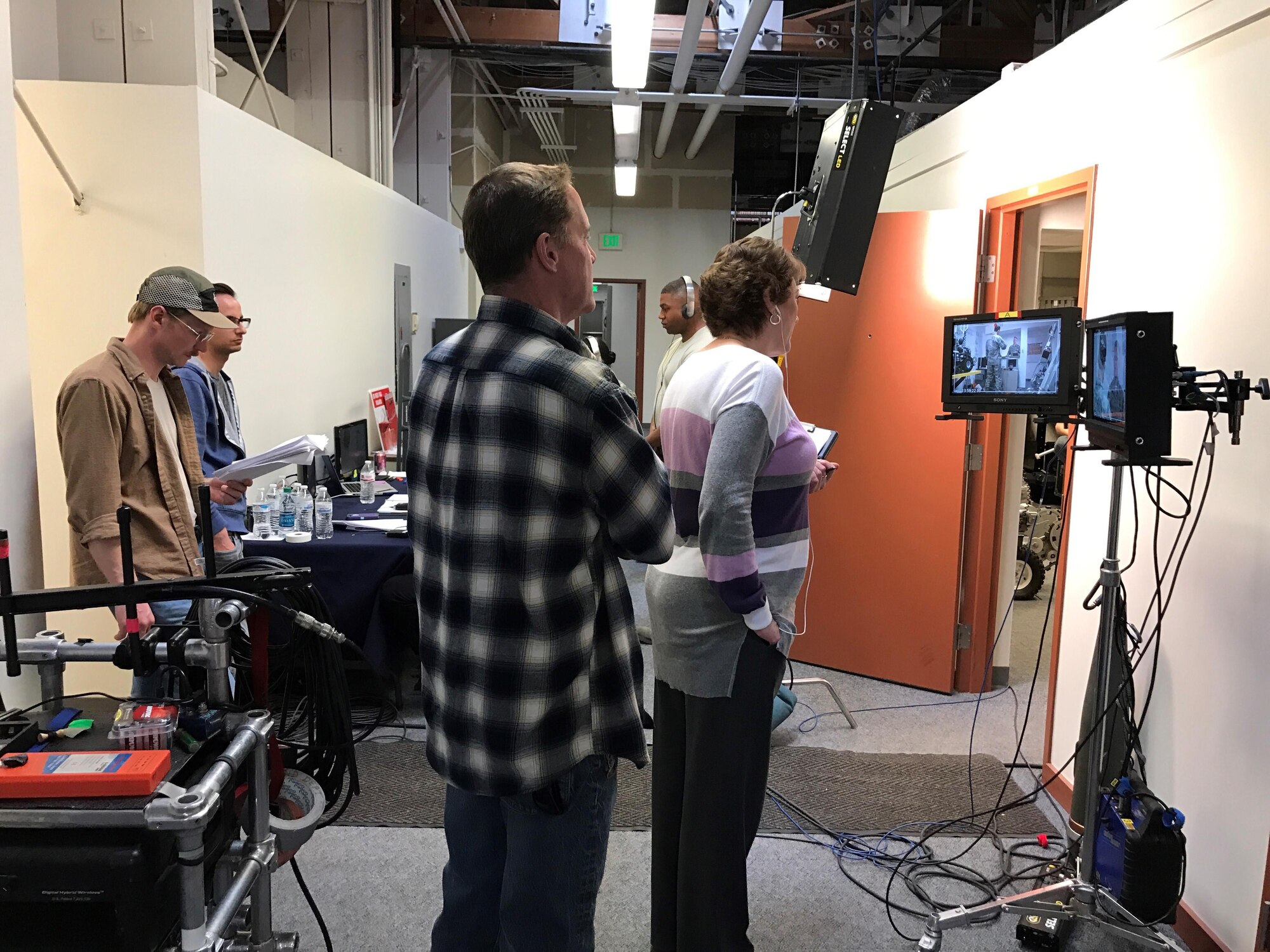 PETERSON AIR FORCE BASE, Colo. - A film crew working the Center of Excellence for Medical Multimedia from the United States Air Force Academy, watches TV monitors as actors perform their lines on camera in the next room at the Explosive Ordnance Disposal building at Peterson Air Force Base, Colorado, March 15, 2017. The film crew was shooting a training video addressing how to recognize symptoms of post-traumatic stress disorder and depression in Airmen.  (U.S. Air Force photo by Tech. Sgt. Joshua Arends)