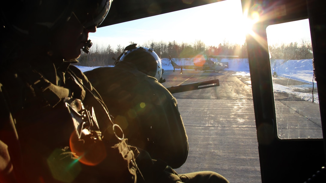 Sgt. Ty Morgan (left) and Cpl. Landon Cheek (center) keep watch out the back of a UH-1Y Venom as it takes off to conduct night-time cold weather operations aboard Fort Drum, N.Y., March 17, 2017. Marines assigned to Marine Light Attack Helicopter Squadron 269, Marine Aircraft Group 29, 2nd Marine Aircraft Wing, conducted close air support at night with live ordnance to simulate real world operations in a forward position. Morgan and Cheek are crew chiefs with HMLA-269. (U.S. Marine Corps photo by Cpl. Mackenzie Gibson/Released)