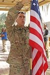 Spc. Michael Chelewski, Joint Visitors Bureau specialist, Combined Joint Forces Land Component Command - Operation Inherent Resolve, hangs a flag in preparation for a promotion ceremony in Baghdad on Dec. 3, 2016. 