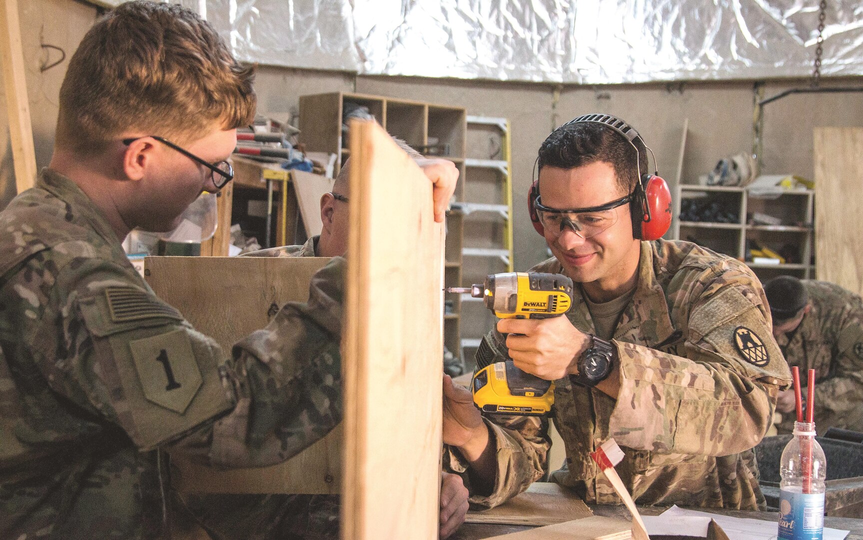 Spc. Daniel Czigler, right, deployed in support of Combined Joint Forces Land Component Command – Operation Inherent Resolve, assigned to 258th Engineer Utilities Detachment, drills into a stand-up desk while Spc. Adam Heath, carpentry and masonry specialist, 258th EUD, holds the desk in place in Baghdad, Iraq, March 6. Czigler is an interior electrician by trade but learned he would be doing a lot of wood work when he arrived.
