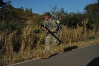 Sgt Ruben Chagolla, assigned to the 35th Expeditionary Signal Battalion, takes advantage and runs downhill during the ruck march portion of the 1st Mission Support Command Best Warrior Competition on Camp Santiago, Puerto Rico, March 15.