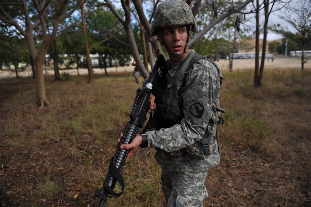 Spc. Jose Ramirez prepares to react to contact during the 1st Mission Support Command Best WarriorCompetition at Camp Santiago, Puerto Rico, March 15