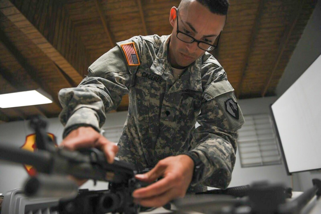 Spc. Jeancarlo Caceres, assigned to 393rd Combat Sustainment Support Battalion, disassembles his weapon during the US Weapons portion of the 1st Mission Support Command Best Warriors Competition held at Camp Santiago, Puerto Rico, March 16.