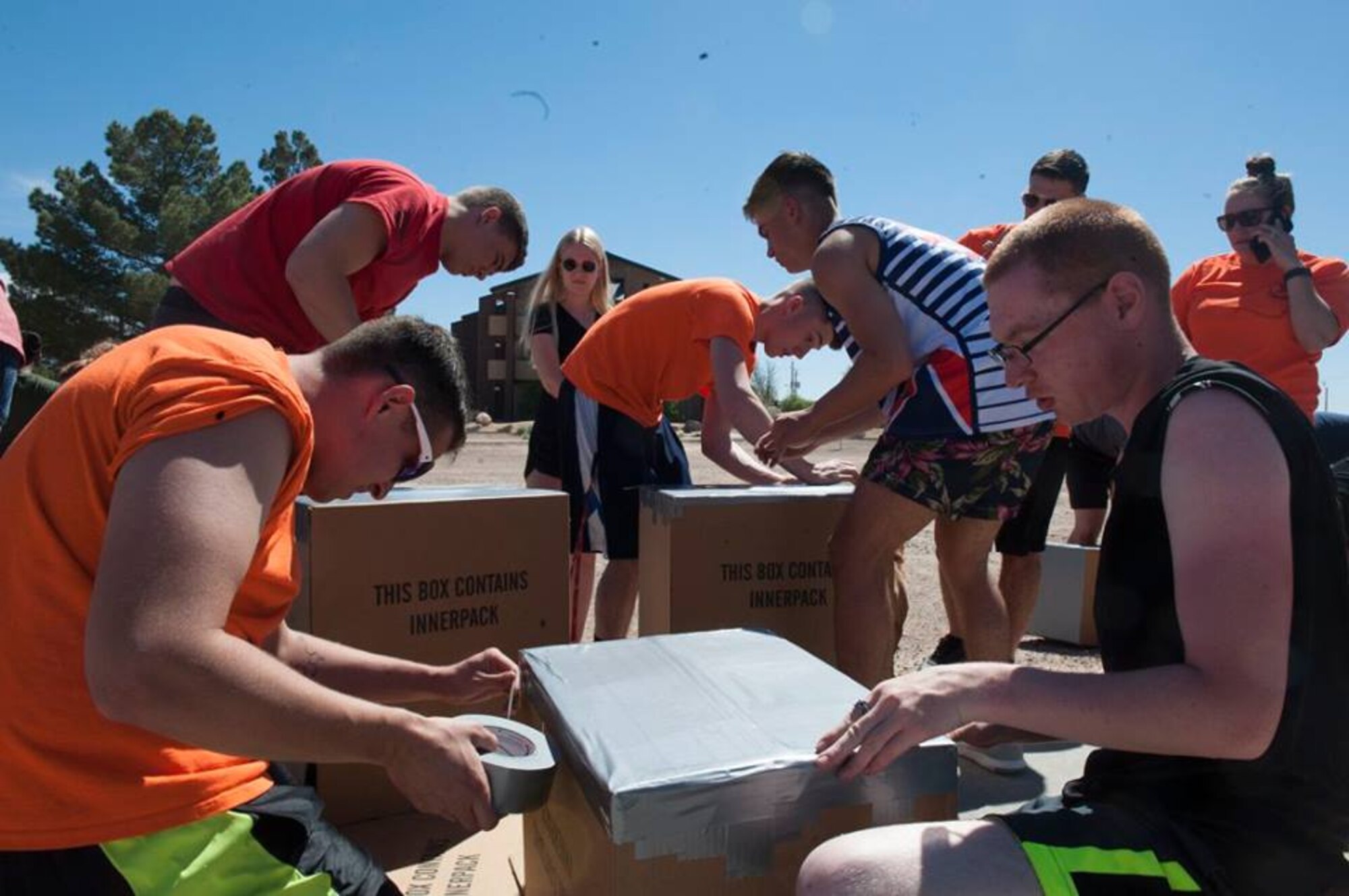 Airmen use cardboard and duct tape to create a boat during the 49th Wing Sports Day, March 17, 2017 at Holloman Air Force Base, N.M. Once completed, Airmen took their boats to the pool for a cardboard boat race. (U.S. Air Force photo by Airman 1st Class Ilyana Escalona)