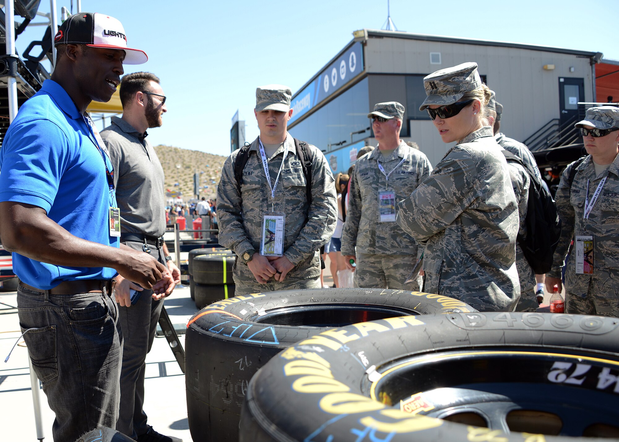 Jesse Iwuji, NASCAR driver, shows Luke Airmen tires that are used for the race during their visit through the garages at the Camping World 500 Mar. 19, 2017, at the Phoenix International Raceway, Avondale, Ariz. (U.S. Air Force photo by Airman First Class Alexander Cook)  