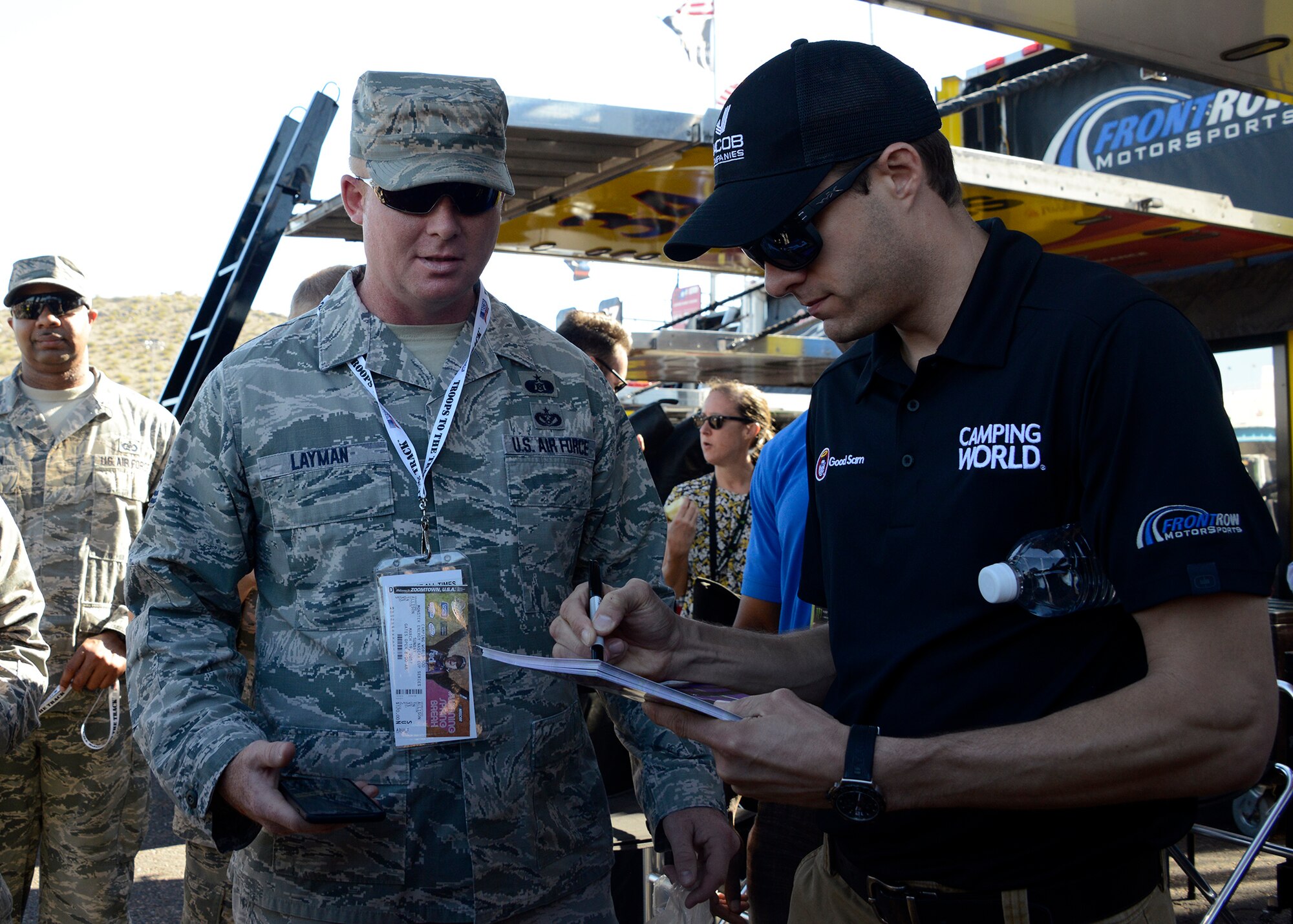 Tech. Sgt. Brandon Layman, 56th Civil Engineer Squadron furnishings management office NCO in charge, awaits a signature from David Ragan, NASCAR driver, during their visit through the garages at the Camping World 500 Mar. 19, 2017, at the Phoenix International Raceway, Avondale, Ariz. (U.S. Air Force photo by Senior Airman Devante Williams)  