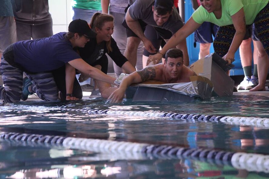 An Airman is pushed forward in his cardboard boat during the 49th Wing Sports Day, March 17, 2017 at Holloman Air Force Base, N.M. Teams assembled cardboard boats then took to the pool, where they raced from one end of the pool to the other. (U.S. Air Force photo by Tech. Sgt. Amanda Junk)