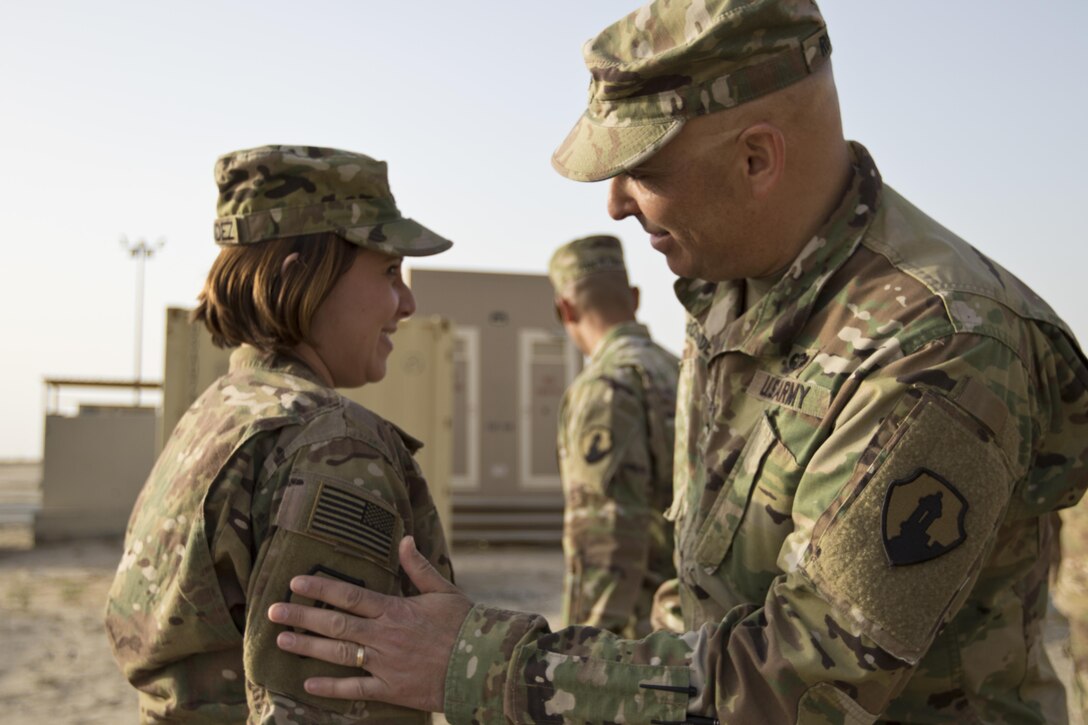 Brig. Gen. Alberto Rosende, commanding general of the 1st Mission Support Command, an Army Reserve unit based out of Fort Buchanan, Puerto Rico, (right) slaps the Garita patch on to 1Lt. Mayra Hernandez, the 246th Quartermaster Company (Mortuary Affairs) USCENTCOM theater mortuary affairs office officer in charge, during a patching ceremony at Camp Arifjan, Kuwait, on Mar. 20, 2017. (U.S. Army photo by Staff Sgt. Dalton Smith)